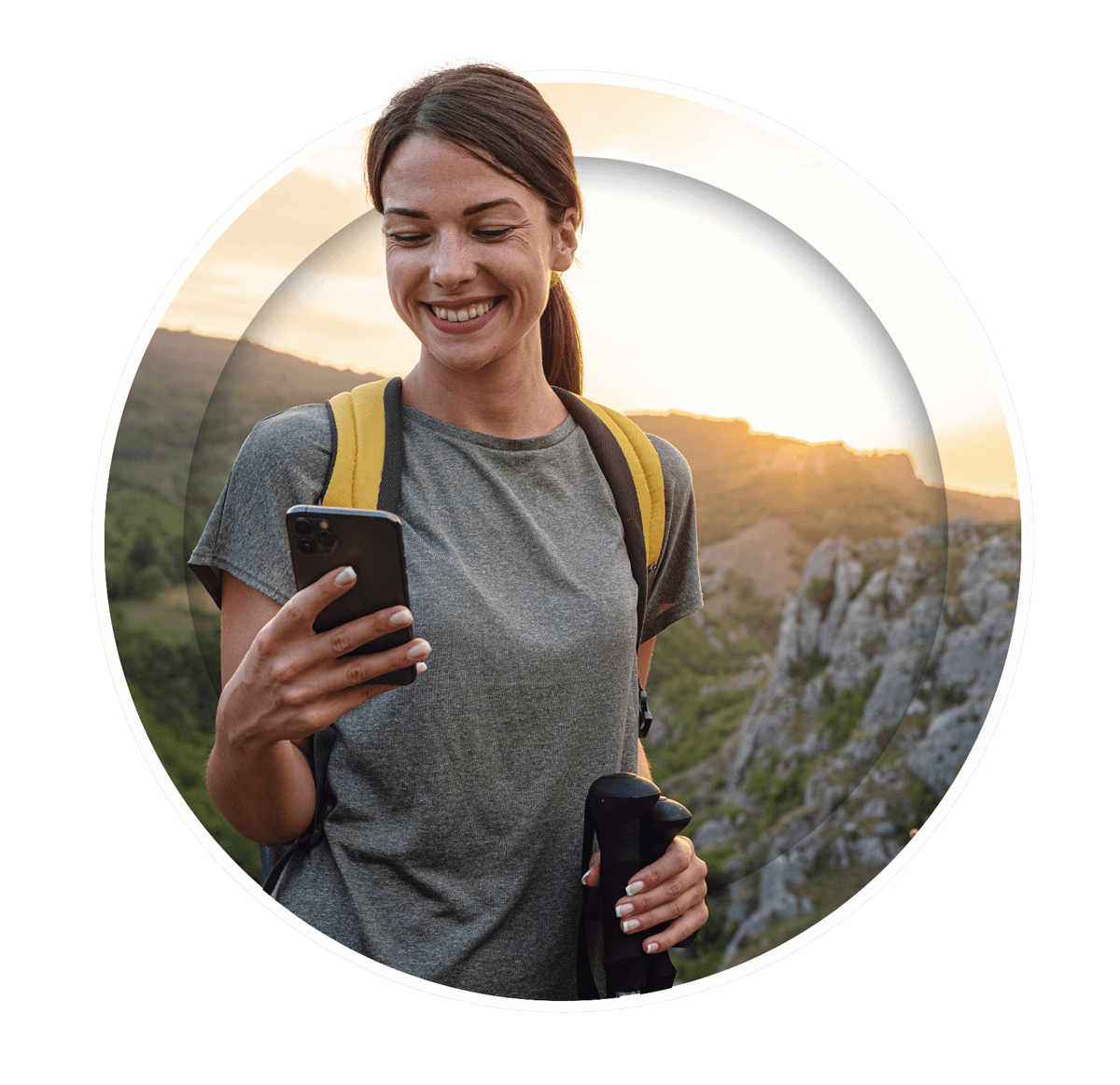 A woman smiles brightly as she looks at her cellphone, appearing pleased and excited by what she sees.
